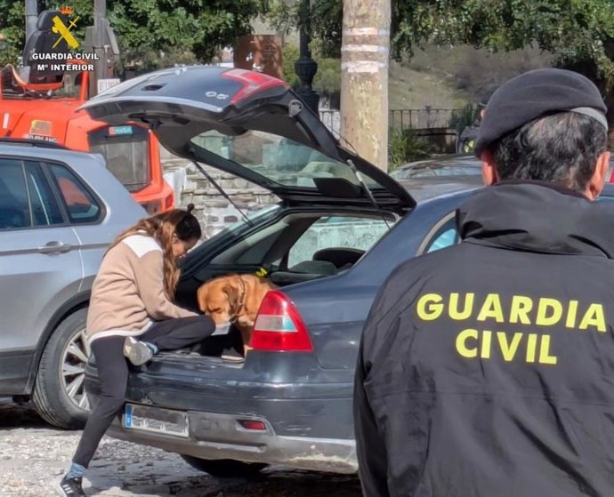 Una vecina de Grazalema con su mascota tras poder volver a su casa a recogerla después de ser desalojada.