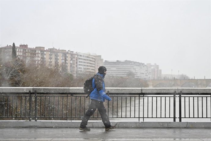 Archivo - Una persona camina por la calle bajo la nieve, a 19 de enero de 2024, en Zaragoza, Aragón (España). La Aemet ha activado la alerta naranja en la provincia de Zaragoza por una acumulación de nieve de hasta 20 centímetros en 24 horas. En total, tr