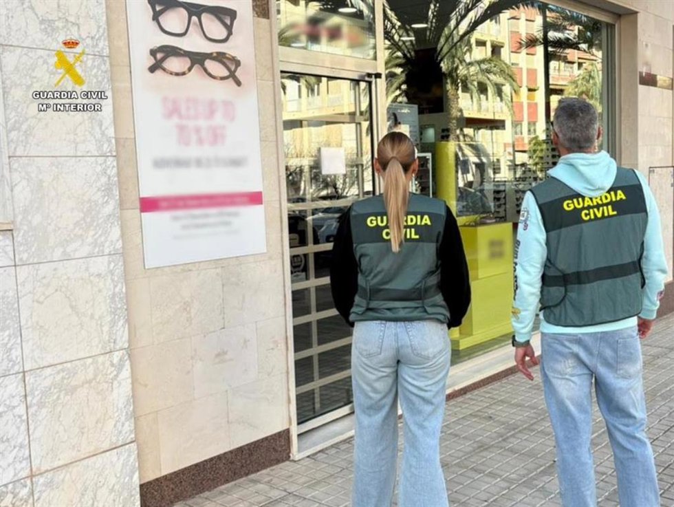 Agentes de la Guardia Civil junto a la óptica ilicitana en la que ocurrió el robo