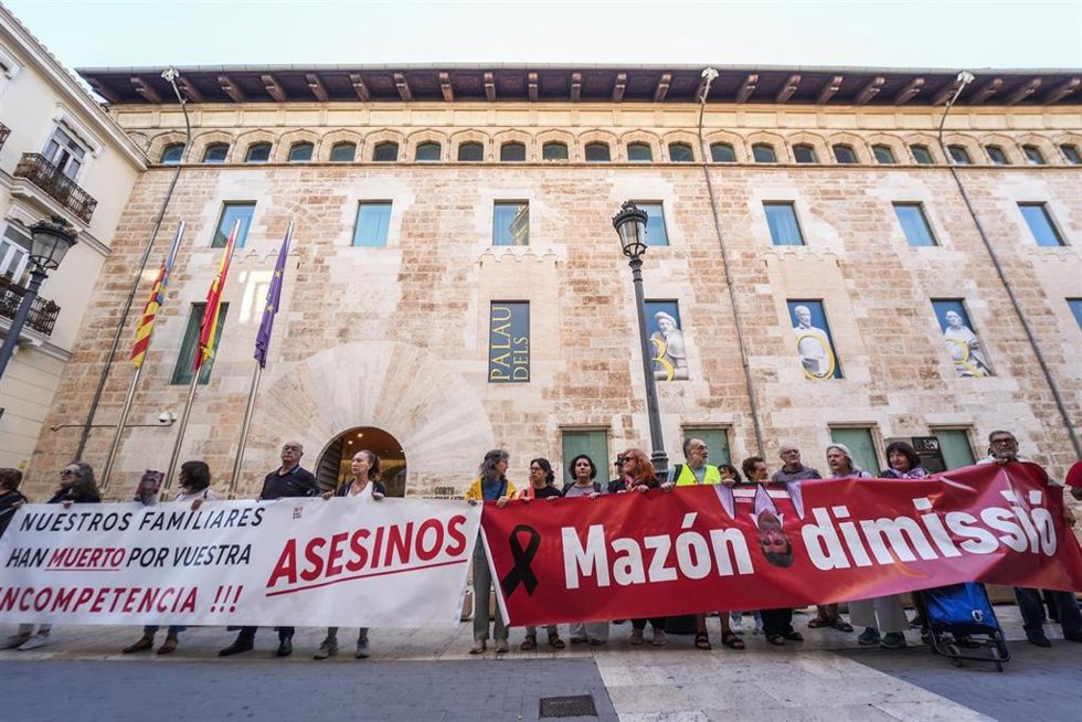 Archivo - Varias personas con pancartas, durante una concentración para pedir la dimisión de Mazón, frente a Les Corts Valencianes, a 23 de septiembre de 2025, en Valencia