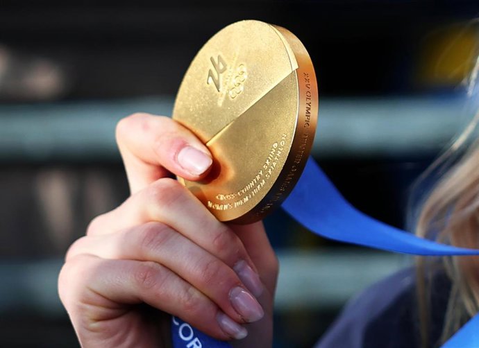 07 February 2026, Italy, Tesero: Sweden's gold-medallist Frida Karlsson holds her medal in her hand after the Women's Nordic skiing/cross-country skiing 10km + 10km Skiathlon competition at the 2026 Winter Olympic games. The manufacture of Olympic medals 