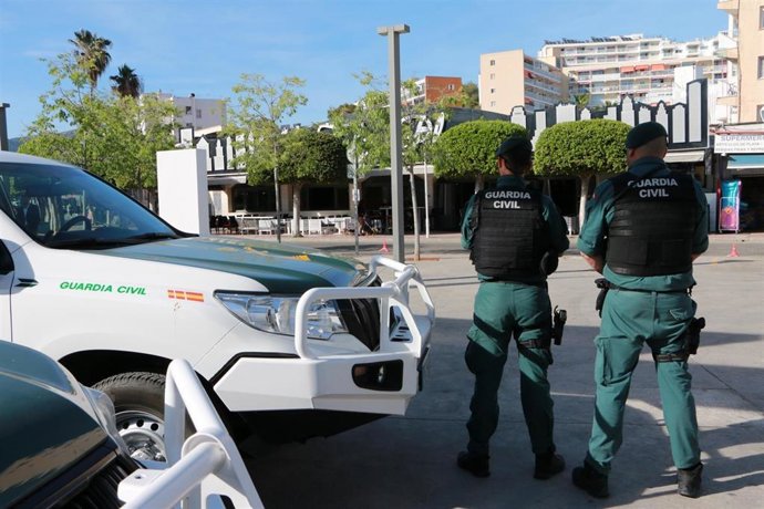 Agentes de la Guardia Civil frente a unos coches patrulla.