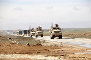 Vehículos militares estadounidenses escoltan autobuses que transportan detenidos de Estado Islámico desde el noreste de Siria a Irak