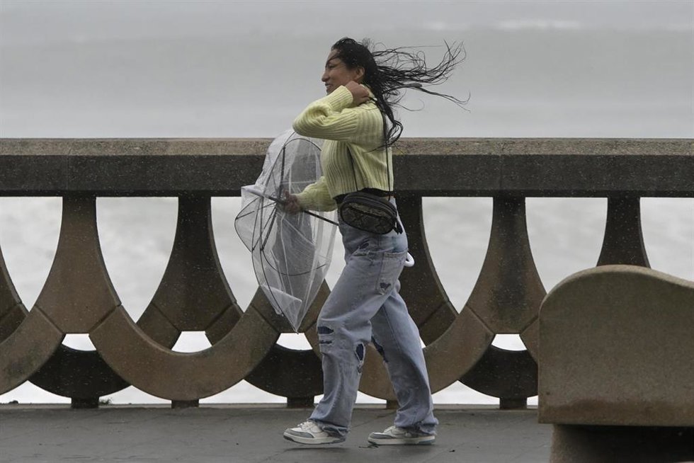 Archivo - Una persona se protege de la lluvia y el viento con un paraguas, a 20 de octubre de 2023, en A Coruña, Galicia (España).