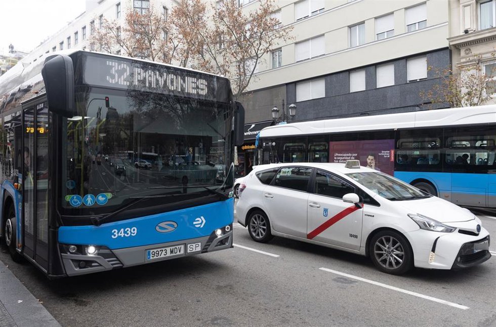 Archivo - Autobuses circulan en una calle de Madrid