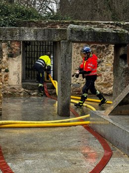 Domberos colocando las mangueras de achique en la Casa de la Moneda de Segovia.