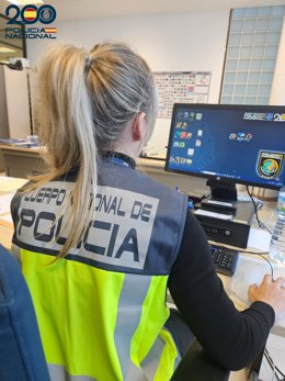 Una agente de la Policía Nacional, de espaldas.