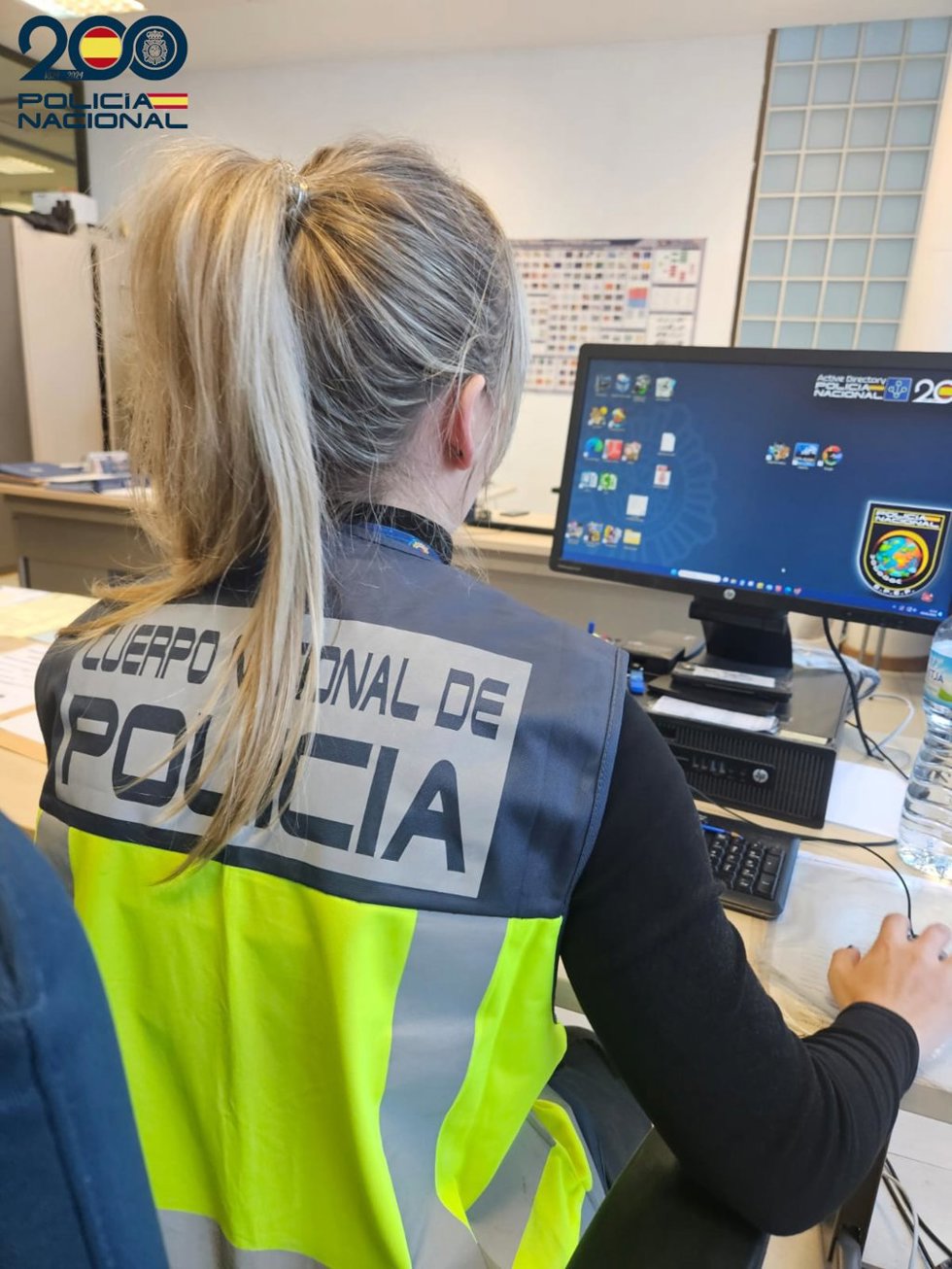 Una agente de la Policía Nacional, de espaldas.