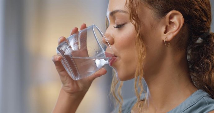 Archivo - Mujer bebiendo un vaso de agua.