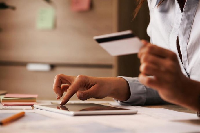 Archivo - Close-up of businesswoman using digital tablet and credit card while checking her online bank account.