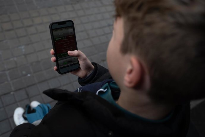 Archivo - Una persona usa el teléfono móvil,  