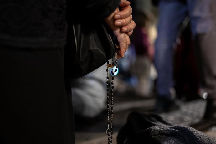 Archivo - Una persona sostiene un rosario.