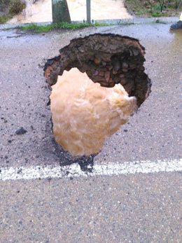 Socavón en la carretera BA-049 provocado por las lluvias.