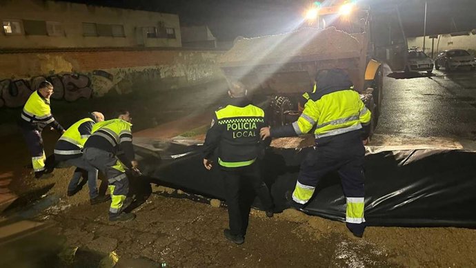 Operarios municipales trabajando en la construcción de diques durante la noche del martes al miércoles.