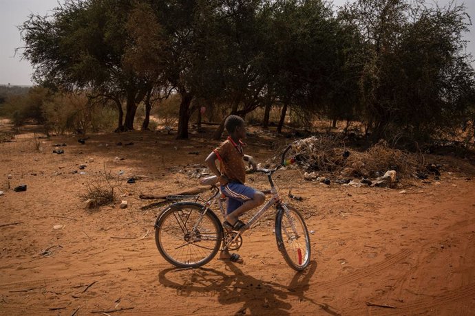 Archivo - Un niño con una bicicleta en un camino de la aldea de Ganguel, a 11 de enero de 2023, en Ganguel, Sokoto, Níger (África).