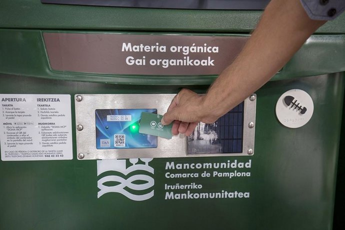 Una persona abre con tarjeta un contenedor de materia orgánica.