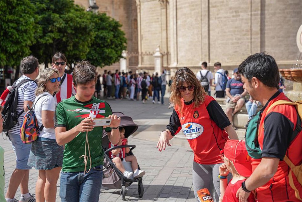 Archivo - Una familia de aficionados del Real Club Mallorca pide a un aficionado del Athletic Club que les haga una fotografía en el entorno de la Catedral, en la Final de Copa de 2024.