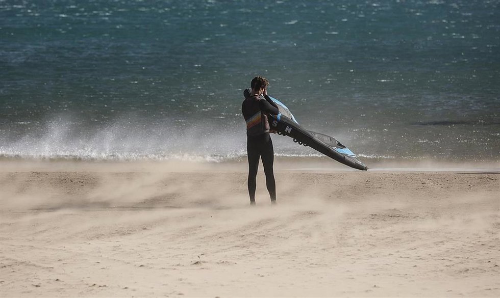 Archivo - Un hombre en la playa de la Malvarrosa, mientras hay fuertes rachas de viento.