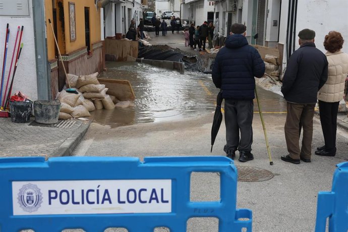 Unos vecinos de Ubrique ante una calle cortada por los efectos del temporal.