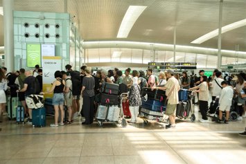 Archivo - Un grupo de personas hacen colas en el Aeropuerto de Barcelona, en una imagen de archivo.