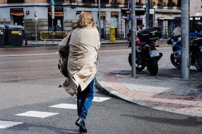 Archivo - Una mujer con el pelo y la chaqueta movidos por el viento, a 2 de noviembre de 2023, en Madrid (España). La Agencia Estatal de Meteorología (AEMET) ha activado la alerta roja en Madrid por fuertes vientos provocados por la borrasca Ciarán. En la