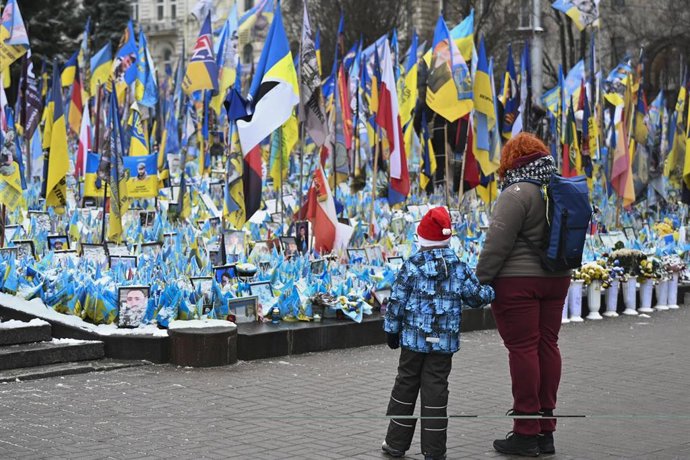 Archivo - Un niño con su madre en frente al memorial por los soldados muertos en Kiev. 