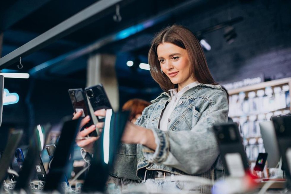 Mujer comparando dos teléfonos móviles