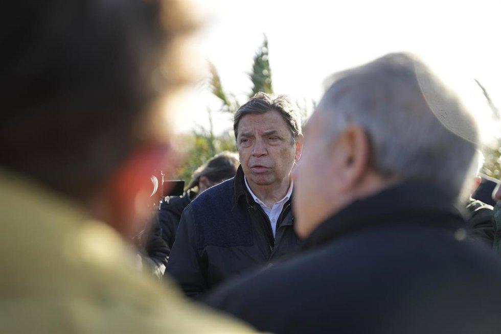El ministro de Agricultura, Pesca y Alimentación, Luis Planas (c), conversa con agricultores afectados en el marco de una visita a zonas golpeadas por el temporal de la provincia de Sevilla