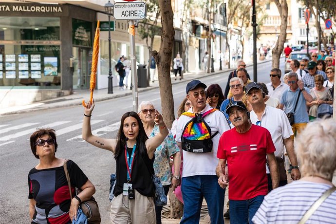 Archivo - Varios turistas con una guía en una calle de Palma