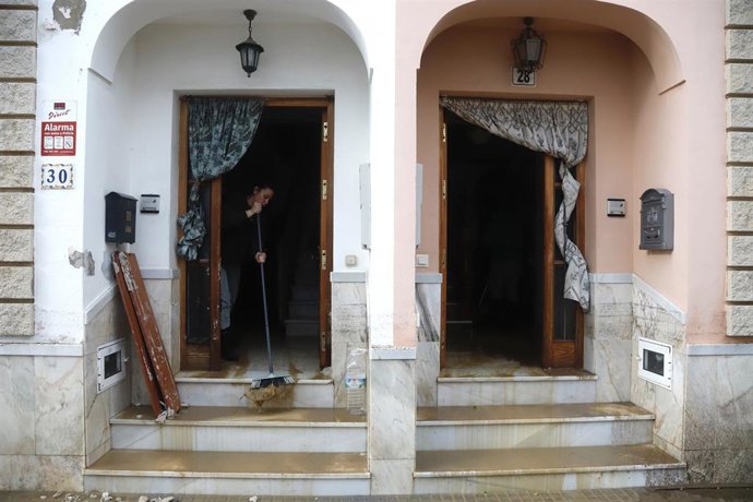 Archivo - Vecinos de la barriada de Los Cardiales en Cártama limpian el barro en sus casas tras las intensas lluvias. 