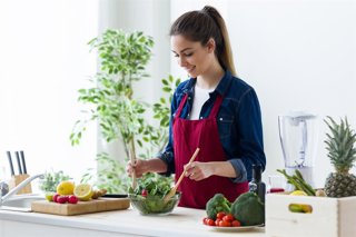 Archivo - Mujer preparando una ensalada.