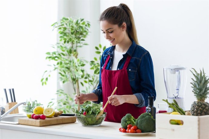 Archivo - Mujer preparando una ensalada.