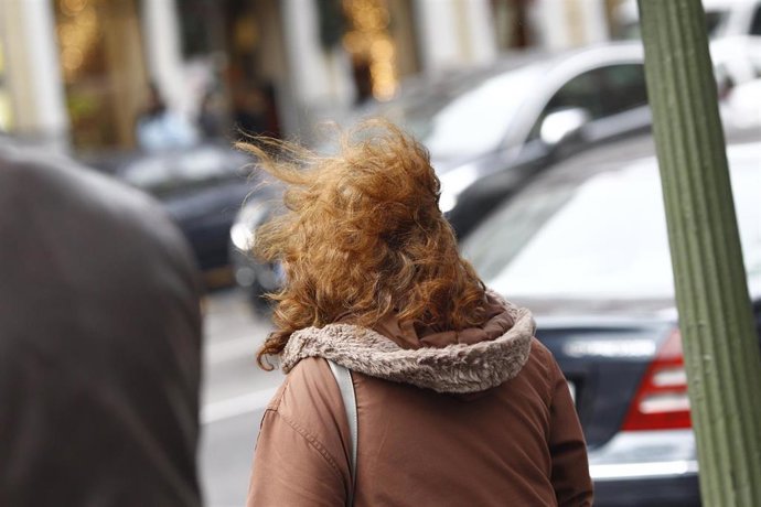 Archivo - Una mujer camina por la calle en un día de viento. Imagen de archivo