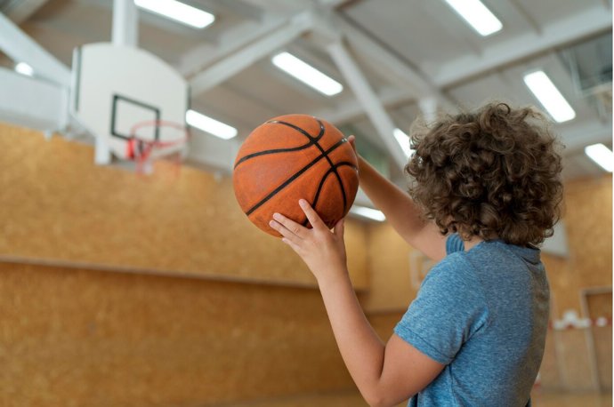 Archivo - Un niño jugando a baloncesto
