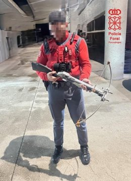 Un agente de la Policía Foral con la bayesta incautada.