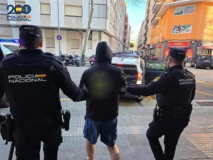 Uno de los detenidos, custodiado por agentes.