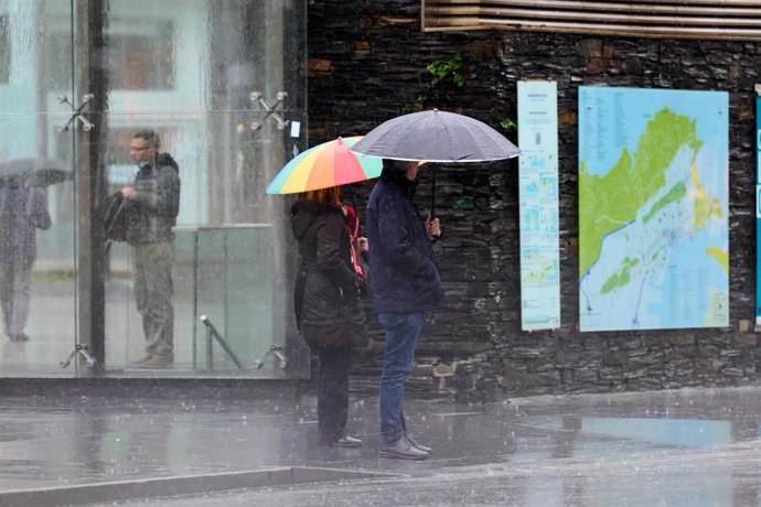 Archivo - Dos personas con paraguas.-ARCHIVO