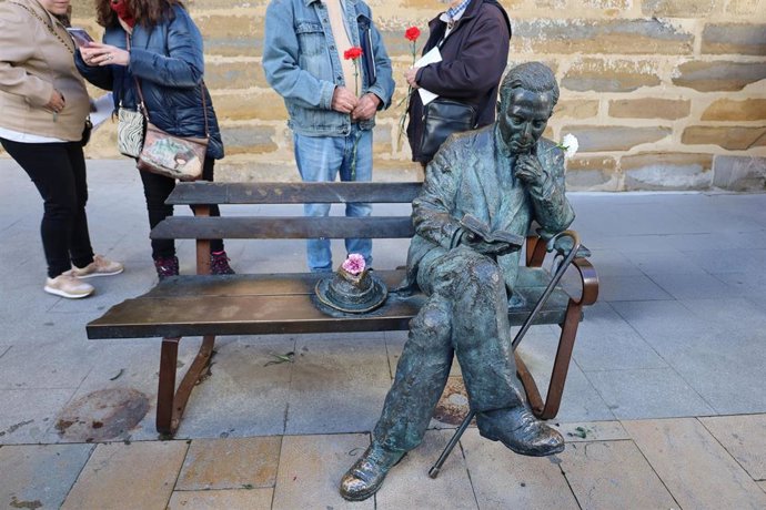 Varias personas junto al monumento dedicado a Antonio Machado en Baeza.