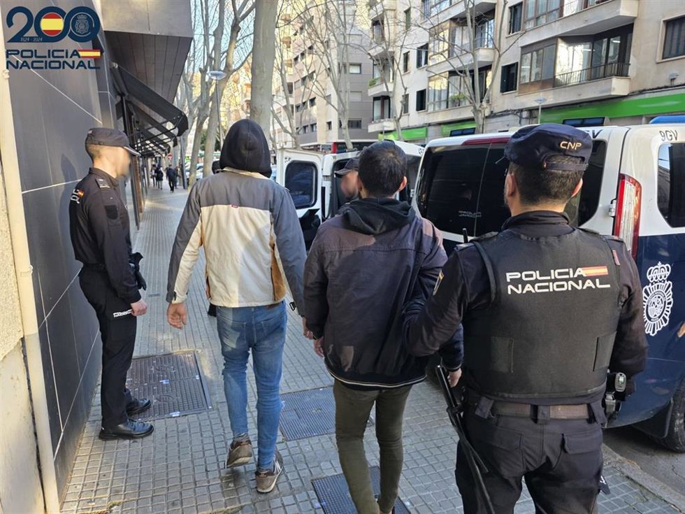 Dos de los detenidos, conducidos por agentes.
