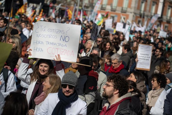 Manifestante porta pancarta con lema '¿Tú cotizas? Nosotros no. Hora trabajada, hora cotizada' durante la manifestación contra el Estatuto Marco del Ministerio de Sanidad
