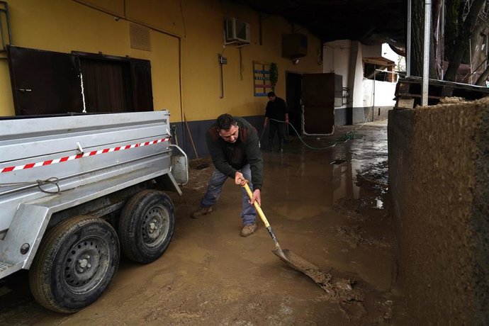 Un hombre limpia barro en Benalúa de las Villas. Archivo.