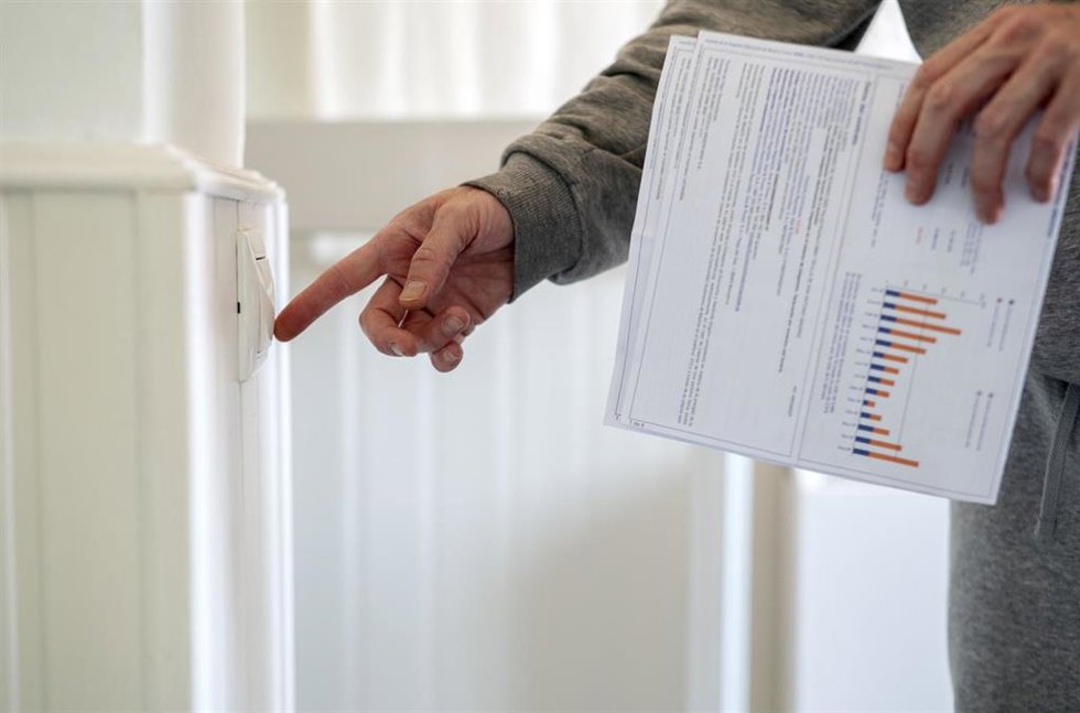 Archivo - Un hombre enciende un interruptor con una factura de luz en la mano, a 3 de enero de 2022, en Madrid, (España). El precio medio de la electricidad en el mercado mayorista vuelve a subir hoy, en concreto un 9,88% con respecto al precio del día