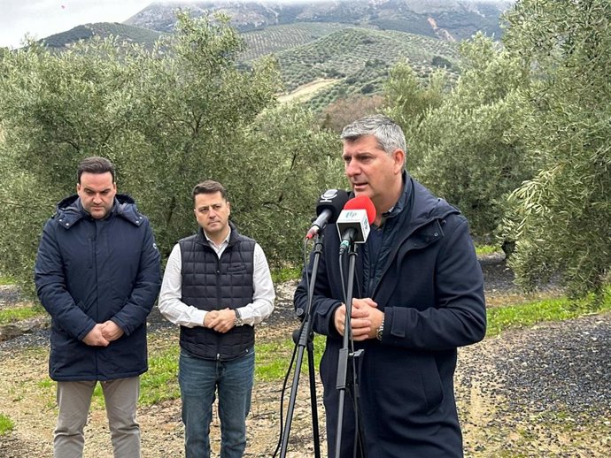 Acosta atiende a los medios, junto a Valdivia (izda.) y Muela (cento), en un olivar de Priego de Córdoba.