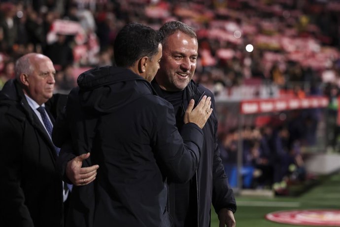 Hansi Flick, treinador principal do FC Barcelona, cumprimenta Michel, treinador principal do Girona FC, durante o jogo de futebol da liga espanhola, LaLiga EA Sports, disputado entre o Girona FC e o FC Barcelona no estádio Montilivi, em 16 de fevereiro de