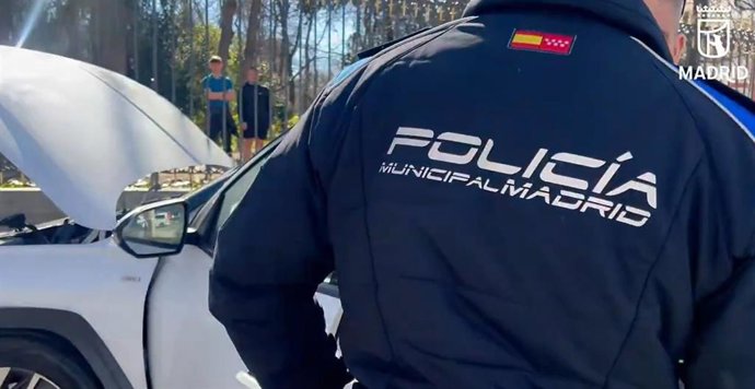Agentes de la Policía Municipal de Madrid durante el atestado tras un accidente de coche en la Puerta de Alcalá, en la acera del Retiro