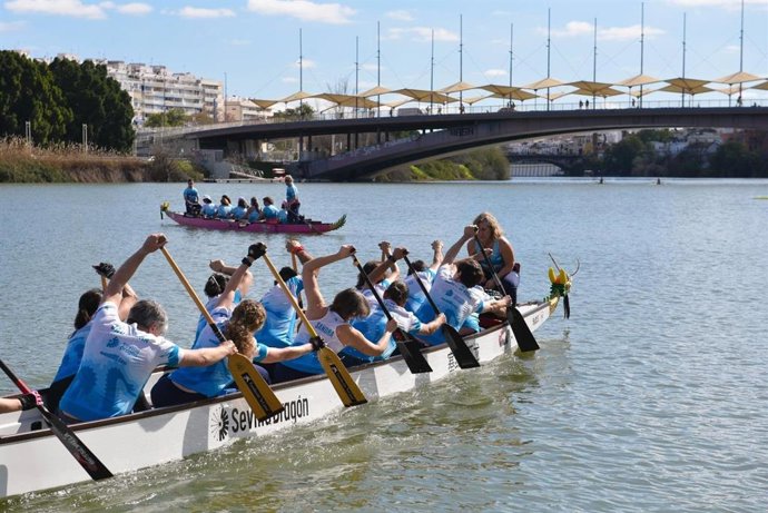 Las integrantes de Las Dragonas reman en su nueva embarcación por el Guadalquivir.