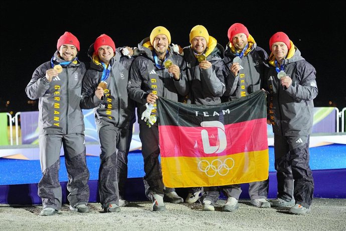 17 February 2026, Italy, Cortina D'ampezzo: (L-R) Germany's bronze medallists Adam Ammour and Alexander Schaller, winners Johannes Lochner and Georg Fleischhauer and silver medallists Francesco Friedrich and Alexander Schueller celebrate their medals at t