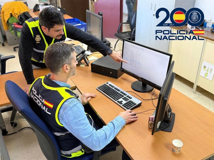 Dos agentes revisan datos en dependencias policiales.