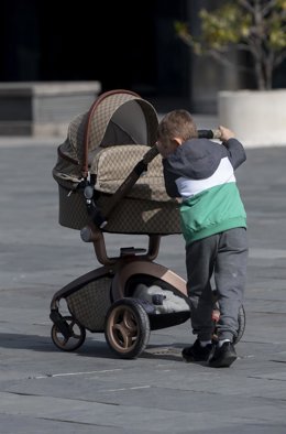 Archivo - Un niño con un carro de un bebe