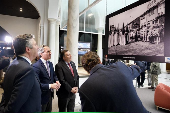 El director de Área de Negocios de CaixaBank en Sevilla, Daniel Pozo (c) junto al fotógrafo de la muestra Jaime Rodríguez) en la inauguración de la X Exposición Fotográfica de Cuaresma
